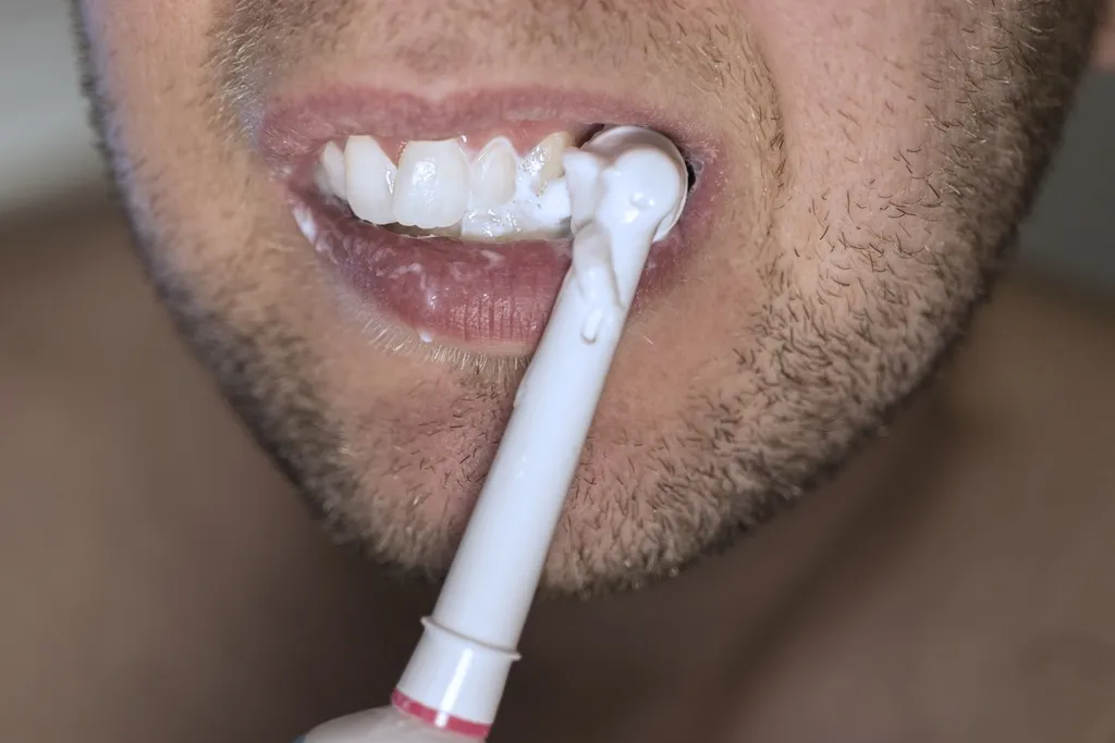 Imagem mostra homem escovando os dentes