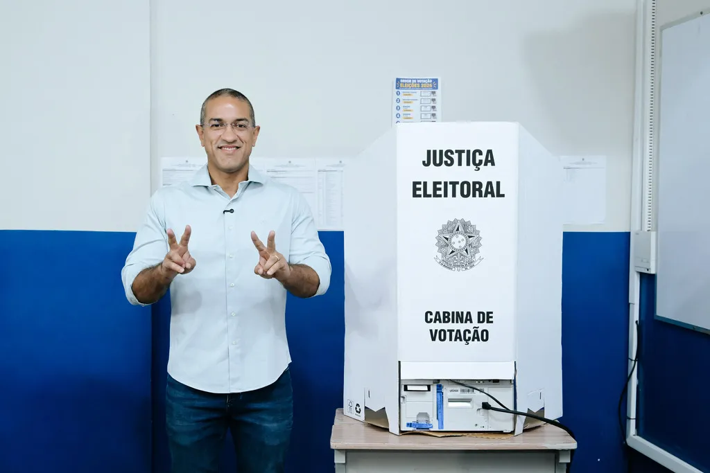 Imagem mostra Arthur Henrique, em frente à cabina de votação, fazendo o V da vitória